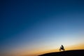 Silhouette of motorcyclist at sunset jumping