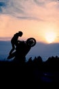 The silhouette of a motorcyclist at sunset.