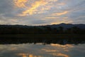 Silhouette of mountain and reflection of cloud in lake or river with forest and sky background at sunset time Royalty Free Stock Photo