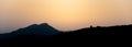 Silhouette of mountains as dusk falls with the sun in the background