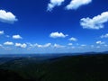 Silhouette of mountains in Bulgaria in summer sunset and many white clouds in the blue sky. Mountainous view. Royalty Free Stock Photo