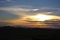 Silhouette of mountains under a blue and yellow cloudy sky Royalty Free Stock Photo