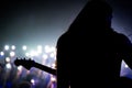 Silhouette of a musician, playing the guitar on the stage in front of a crowd at a concert Royalty Free Stock Photo