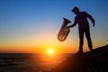 Silhouette of musician with the trumpet on rocky sea coast . Royalty Free Stock Photo