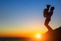 Silhouette of musician with the tuba/trumpet on rocky sea coast. Royalty Free Stock Photo