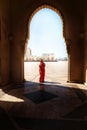 Full length silhouette of a Muslim Arabian woman in hijab and traditional clothes standing under marble arch of mosque Royalty Free Stock Photo