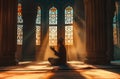 Silhouette of muslim man sitting while raised hands and praying in mosque with Islamic concept Royalty Free Stock Photo