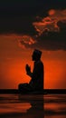 Silhouette of muslim man sitting while raised hands and praying in mosque with Islamic concept Royalty Free Stock Photo