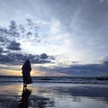 silhouette of muslim woman on the beach waiting for sunset is very beautiful in the distance Royalty Free Stock Photo