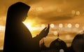 Silhouette of muslim woman praying with prayer beads