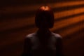 Silhouette of a mysterious red-haired woman with bare shoulders, portrait of an incognito girl, unrecognizable naked girl against Royalty Free Stock Photo