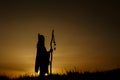 silhouette of native american shaman with pikestaff on background of sunset beutiful in mountains