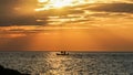 A small fishing boat moored in the middle of the sea during sunset in Thailand Royalty Free Stock Photo