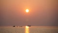 A small fishing boat moored in the middle of the sea during sunset in Thailand Royalty Free Stock Photo