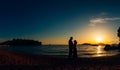 Silhouette of a newlywed couple at the sea at sunset. Wedding in