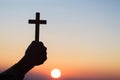 Silhouette off hands holding wooden cross on sunrise background, Crucifix, Symbol of Faith