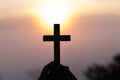 Silhouette off hands holding wooden cross on sunrise background, Crucifix, Symbol of Faith