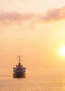 Silhouette Oil Tanker Ship is sailing in the sea with beautiful golden sunlight at sunset time in vertical frame Royalty Free Stock Photo