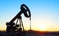 A silhouette of an oil well drilling for oil.