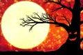 Silhouette of an old black tree with a grimace on the trunk against the background of an orange sky with the moon