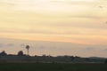 The silhouette of an old windmill on a farm in a golden sunset. Barker in Uruguay Royalty Free Stock Photo