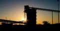 Silhouette of an open-pit manganese mining industry equipment on background of the sunsey