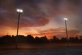 Silhouette of outdoor light pole in local sport park with dramatic sky in the sunrise morning Royalty Free Stock Photo