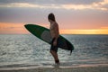 Silhouette paddle board surfer on the sunset background.