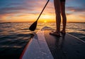 Silhouette of paddleboarder on tranquil water during vibrant sunset Royalty Free Stock Photo