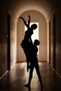 Silhouette of pair of professional dancers in corridor of some old theatre performing ballet gimmicks