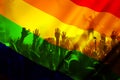 silhouette of a parade of gays and lesbians with a rainbow flag - symbol of love and tolerance