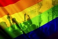 silhouette of a parade of gays and lesbians with a rainbow flag - symbol of love and tolerance