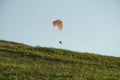 Silhouette of paraglide flying in the sky with clouds in a light of sunrise. Ukrainian Carpathian valley