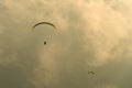 Silhouette of paragliders in a wonderful sunset light flying in clouds