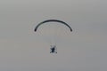 Silhouette of the Paramotor gliding and flying In the air through soft sunlight sky Royalty Free Stock Photo