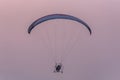 Silhouette of the Paramotor gliding and flying In the air through soft sunlight sky Royalty Free Stock Photo