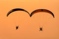 Silhouette of the Paramotor gliding and flying In the air through soft sunlight sky Royalty Free Stock Photo