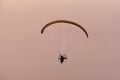 Silhouette of the Paramotor gliding and flying In the air through soft sunlight sky Royalty Free Stock Photo