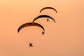 Silhouette of the Paramotor gliding and flying In the air through soft sunlight sky Royalty Free Stock Photo