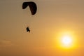 Silhouette of Paramotors flying to sky on sunset Adventure man active extreme sport pilot flying in sky with paramotor engine glid Royalty Free Stock Photo