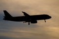 Silhouette passenger airplane flying away in to sky high altitude on sunset