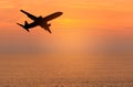 Silhouette passenger airplane flying away in to sky high altitude during sunset time