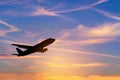 Silhouette passenger airplane flying away in to sky during sunset