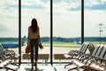 Silhouette of female airline passenger in an airport lounge waiting for flight aircraft Royalty Free Stock Photo