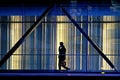 Silhouette of a pedestrian crossing an illuminated covered walkway through downtown Toronto