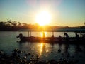 Silhouette of people in a boat sailing on the river at sunset.