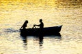 silhouette of people in boats with oars on the evening river Royalty Free Stock Photo