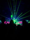 Silhouette people crowd happy and cheering with led foam stick light in front of bright colorful stage lights Royalty Free Stock Photo