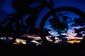 Silhouette of people cycling at sunset, sky with clouds and light purple, pink Royalty Free Stock Photo