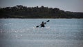 Silhouette of people doing water sport activity in calming water